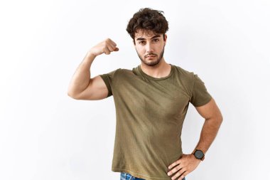 İzole edilmiş beyaz arka planda duran İspanyol adam güçlü kol kası gösteren, kendinden emin ve gururlu biri. 