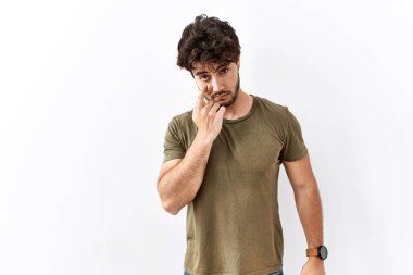 İzole edilmiş beyaz arka planda duran İspanyol bir adam senin jestini ve şüpheli ifadesini izleyerek göze işaret ediyor. 