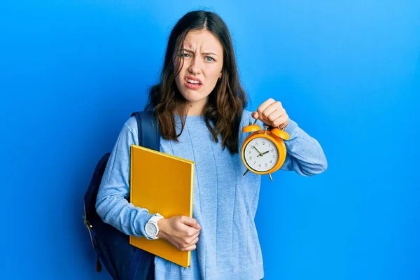 Young Brunette Student Woman Holding Alarm Clock Clueless Confused Expression — 스톡 사진