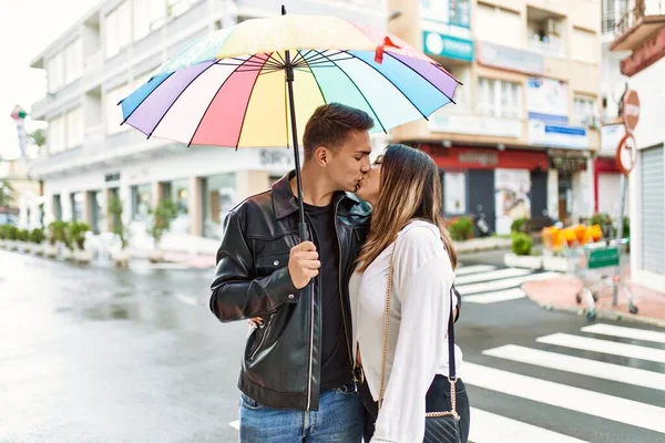 年轻夫妇接吻 手握雨伞站在城中 — 图库照片