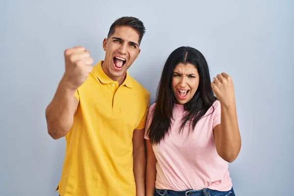 Young Couple Standing Isolated Background Angry Mad Raising Fist Frustrated — Stockfoto
