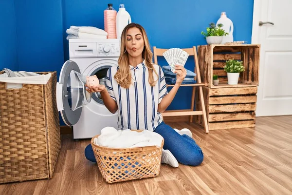 Young blonde woman doing laundry saving money making fish face with mouth and squinting eyes, crazy and comical.