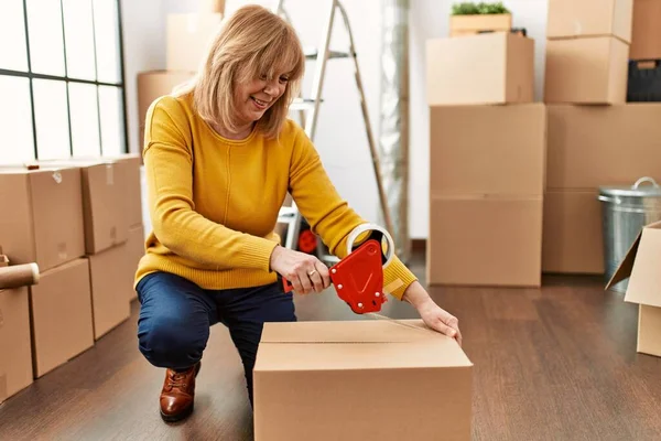 Middelbare Leeftijd Blonde Vrouw Verpakking Doos Met Behulp Van Tape — Stockfoto