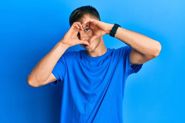 Young Caucasian Man Wearing Casual Blue Shirt Doing Heart Shape — 스톡 사진