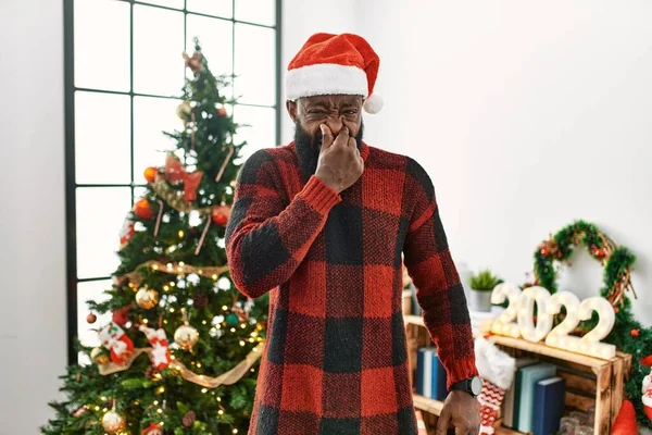 Afrikanischer Mann Mit Weihnachtsmannmütze Der Weihnachtsbaum Steht Und Etwas Stinkt — Stockfoto