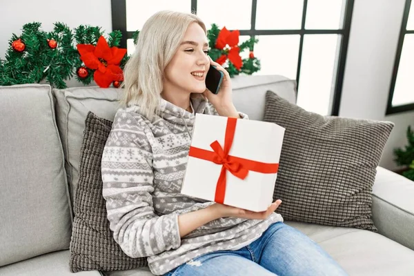Молода Біла Дівчина Розмовляє Смартфону Тримаючи Різдвяний Подарунок Вдома — стокове фото