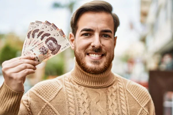 Joven Caucásico Sonriendo Feliz Sosteniendo Billetes Mexicanos Ciudad —  Fotos de Stock