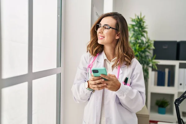 Jovem Mulher Vestindo Uniforme Médico Usando Smartphone Clínica — Fotografia de Stock