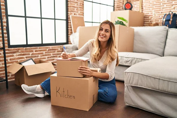 Young Blonde Woman Smiling Confident Writing Book New Home — Stock Photo, Image