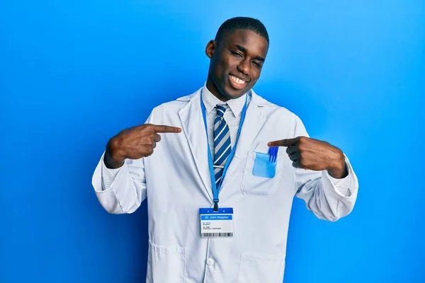 Young African American Man Wearing Scientist Uniform Looking Confident Smile — стоковое фото