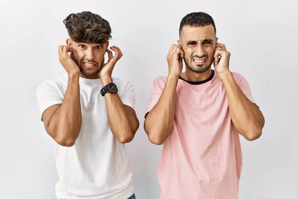 Young Gay Couple Standing Isolated Background Covering Ears Fingers Annoyed — Foto Stock