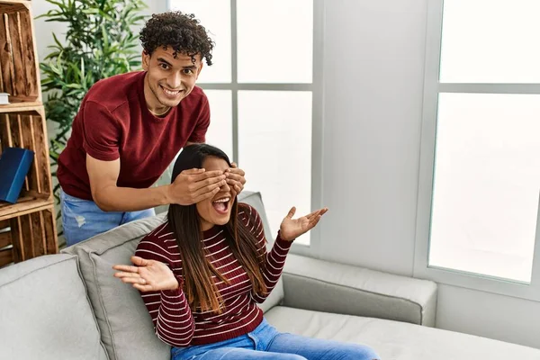 Man Surprising His Girlfriend Hands Eyes Sitting Sofa Home — Stock fotografie