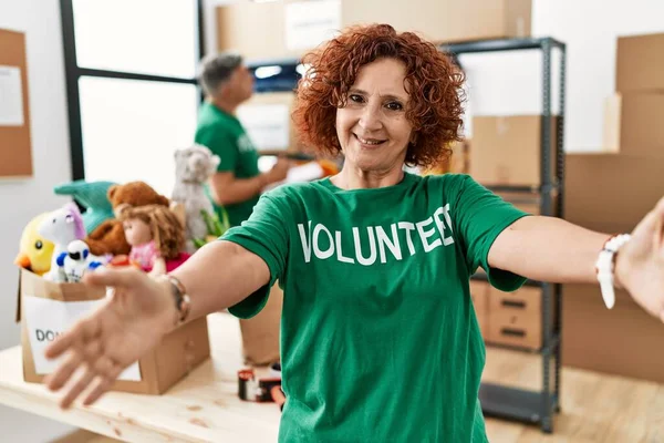 Bağışta Gönüllü Tişört Giyen Orta Yaşlı Bir Kadın Kameraya Sarılmak — Stok fotoğraf