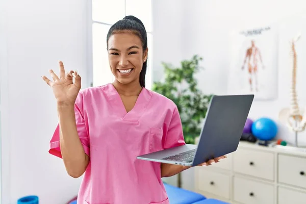 Νεαρή Ισπανόφωνη Φυσιοθεραπεύτρια Γυναίκα Χρησιμοποιώντας Φορητό Υπολογιστή Στην Ιατρική Κλινική — Φωτογραφία Αρχείου