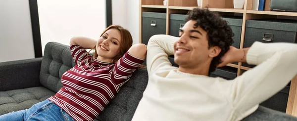 Jovem Casal Sorrindo Feliz Relaxado Com Mãos Cabeça Sentado Sofá — Fotografia de Stock