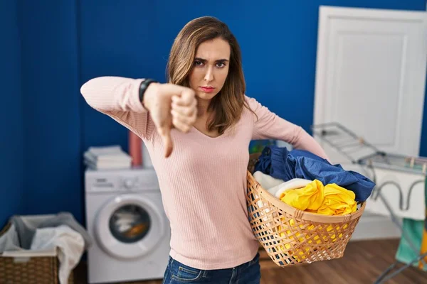 Young Woman Holding Laundry Basket Looking Unhappy Angry Showing Rejection — Stockfoto