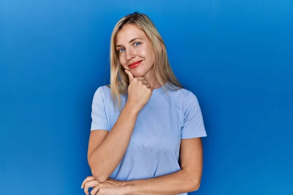 Mooie Blonde Vrouw Draagt Casual Shirt Blauwe Achtergrond Kijken Zelfverzekerd — Stockfoto