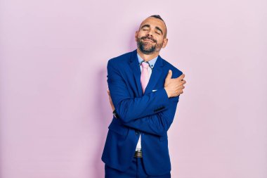 Genç İspanyol bir adam iş elbisesi ve kravat takıyor mutlu ve pozitif, kendinden emin gülümsüyor. Sevgi ve özgüven. 