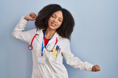 Genç Afro-Amerikan kadın doktor üniforması ve steteskop giyiyor, yorgun ve rahat, uykulu ve sabahın erken saatleri için esniyor. 