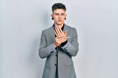 Kulakları genişlemiş, iş ceketi giymiş, elleri ve parmakları ağrıyan, eklem iltihabı olan beyaz çocuk. 