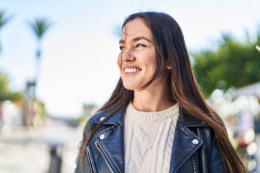 Sokakta kendinden emin gülümseyen genç bir kadın