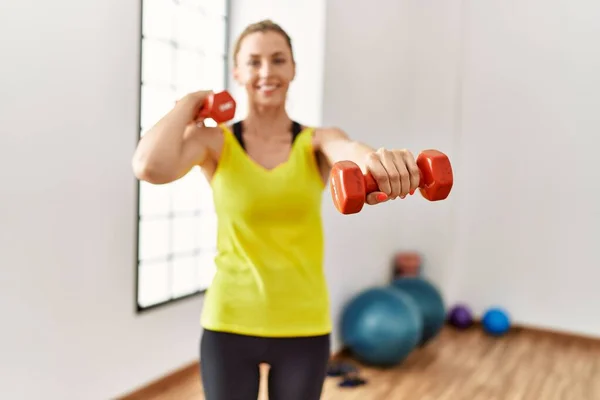 Joven Chica Rubia Sonriendo Feliz Entrenamiento Usando Mancuernas Centro Deportivo — Foto de Stock