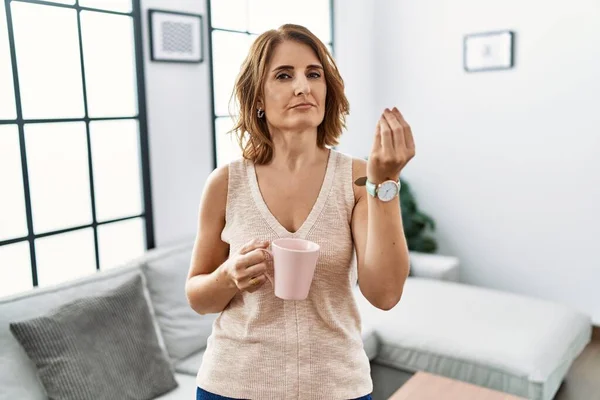 Middle Age Woman Drinking Cup Coffee Home Doing Italian Gesture — 스톡 사진