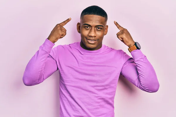 Young Black Man Wearing Casual Pink Sweater Smiling Pointing Head — ストック写真