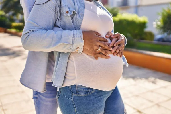 Young Latin Couple Expecting Baby Touching Belly Hugging Each Other — Stockfoto