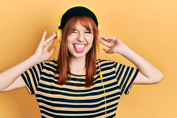 Redhead Ung Kvinna Lyssnar Musik Med Hörlurar Sticker Tungan Glad — Stockfoto