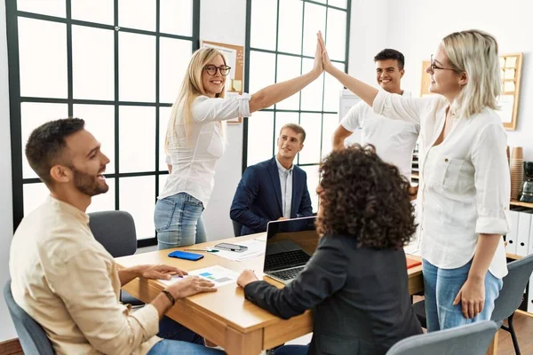 Ofiste buluşurken gülümseyen iki işçi beşlik çakıyor..