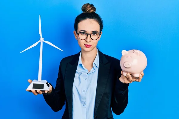 Young Hispanic Girl Holding Windmill Piggy Bank Relaxed Serious Expression — Fotografia de Stock