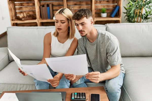 Evde dizüstü bilgisayar kullanarak aile ekonomisini kontrol eden ciddi ifadeleri olan beyaz bir çift..