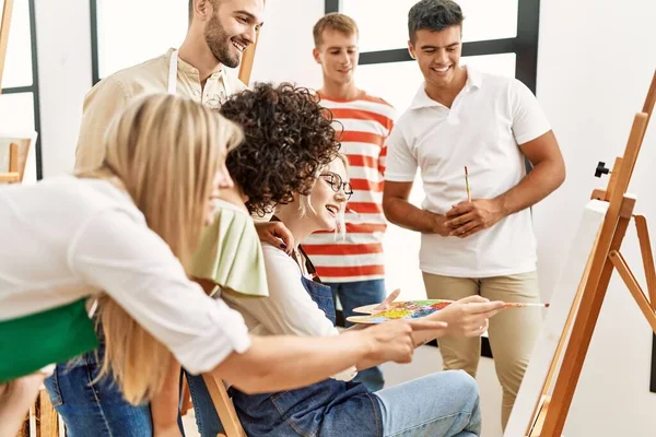 Mutlu gülümseyen ve ortak arayan bir grup insan sanat stüdyosunda..