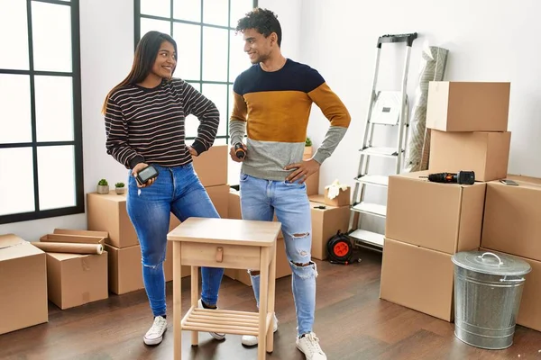 Genç Latin çift gülümsüyor mutlu mobilyaları yeni evlerinde birleştiriyorlar..