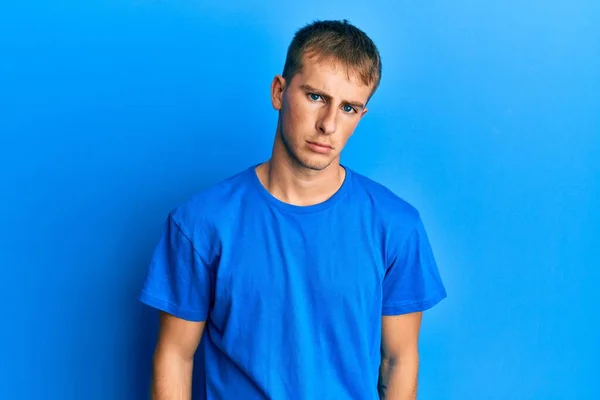 年轻的高加索人穿着休闲的蓝色T恤 忧心忡忡 哭哭啼啼 悲伤的表情 — 图库照片