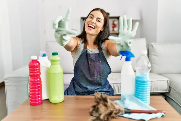 Młoda Brunetka Ubrana Czystszy Fartuch Rękawiczki Sprzątanie Domu Pokazując Wskazując — Zdjęcie stockowe