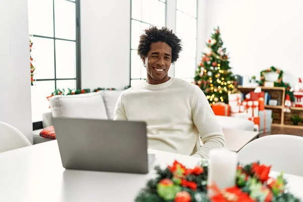 Joven Afroamericano Hombre Usando Portátil Sentado Mesa Por Árbol Navidad — Foto de Stock