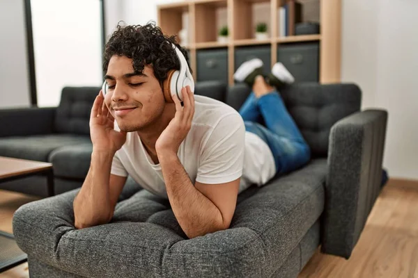 Joven Hispano Escuchando Música Tumbado Sofá Casa —  Fotos de Stock