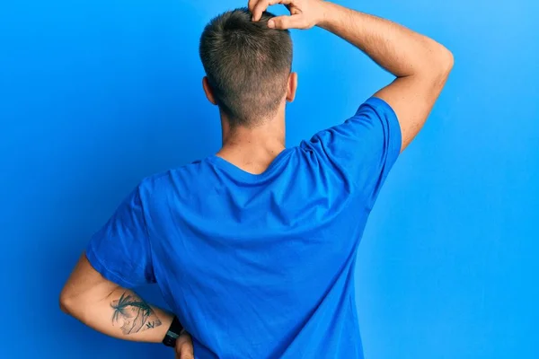 Νεαρός Καυκάσιος Άντρας Που Φοράει Μπλε Μπλουζάκι Ανάποδα Σκεπτόμενος Την — Φωτογραφία Αρχείου