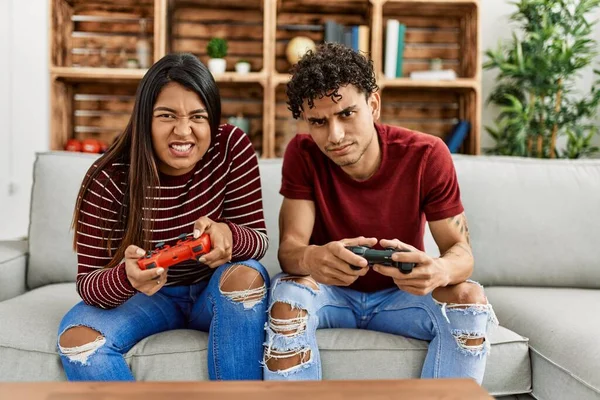 Young Latin Couple Unhappy Playing Video Game Sitting Sofa Home — Stockfoto