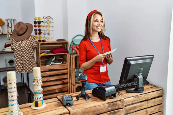 Kafkasyalı genç bir esnaf dükkanında elinde dolarlarla mutlu bir şekilde gülümsüyor..