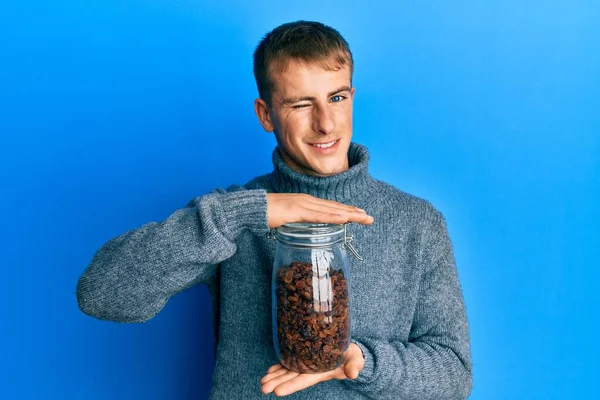 Young Caucasian Man Holding Jar Raisins Winking Looking Camera Sexy — стоковое фото