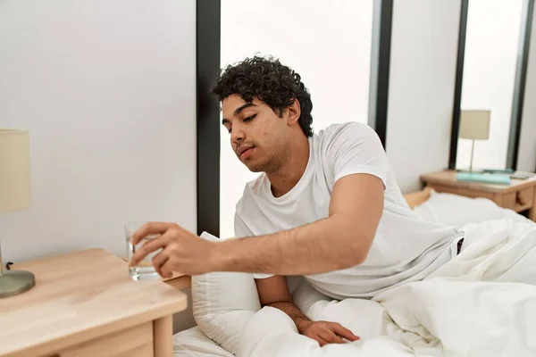 Jonge Spaanse Man Drinkwater Zittend Het Bed Slaapkamer — Stockfoto