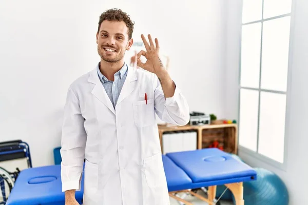 Ağrı Giderme Kliniğinde Çalışan Yakışıklı Genç Adam Gülümsüyor Parmaklarıyla Tamam — Stok fotoğraf