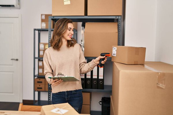 Young woman ecommerce business worker scanning package at office