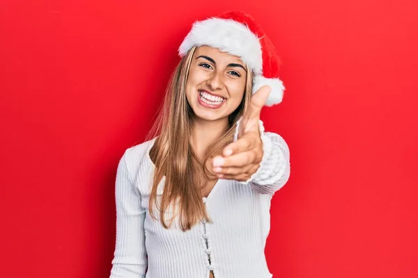 Красива Іспаномовна Жінка Різдвяному Капелюсі Посміхається Доброзичливо Пропонуючи Рукостискання Привітання — стокове фото