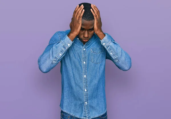 身穿休闲服的年轻的非洲裔美国人 由于疼痛和偏头痛 绝望和压力重重 手放在头上 — 图库照片