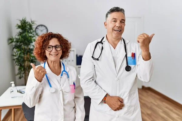 Dois Médicos Meia Idade Clínica Médica Sorrindo Com Rosto Feliz — Fotografia de Stock