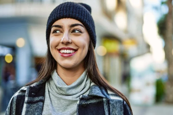 Genç İspanyol kadın gülümseyerek şehirde mutlu mesut dikiliyor..
